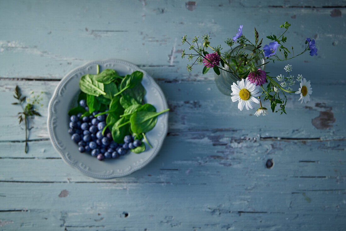 Plate with blueberries and fresh spinach