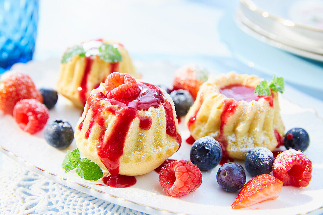 Mini cakes with raspberry sauce and berries