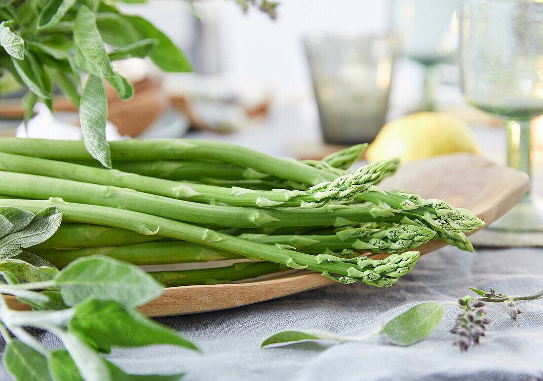Fresh green asparagus on a wooden platter