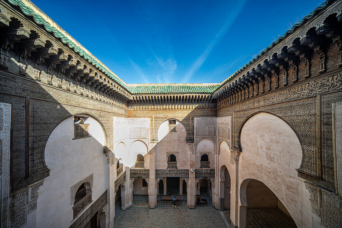 Ein ruhiger Blick durch das verschnörkelte Fenster der Cherratine Madrasa fängt die Essenz von Fez ein. Fez, Marokko.