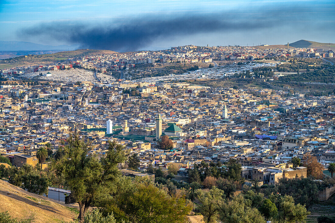 The sprawling Fez Medina under a clouded sky, as seen from the northern hills.