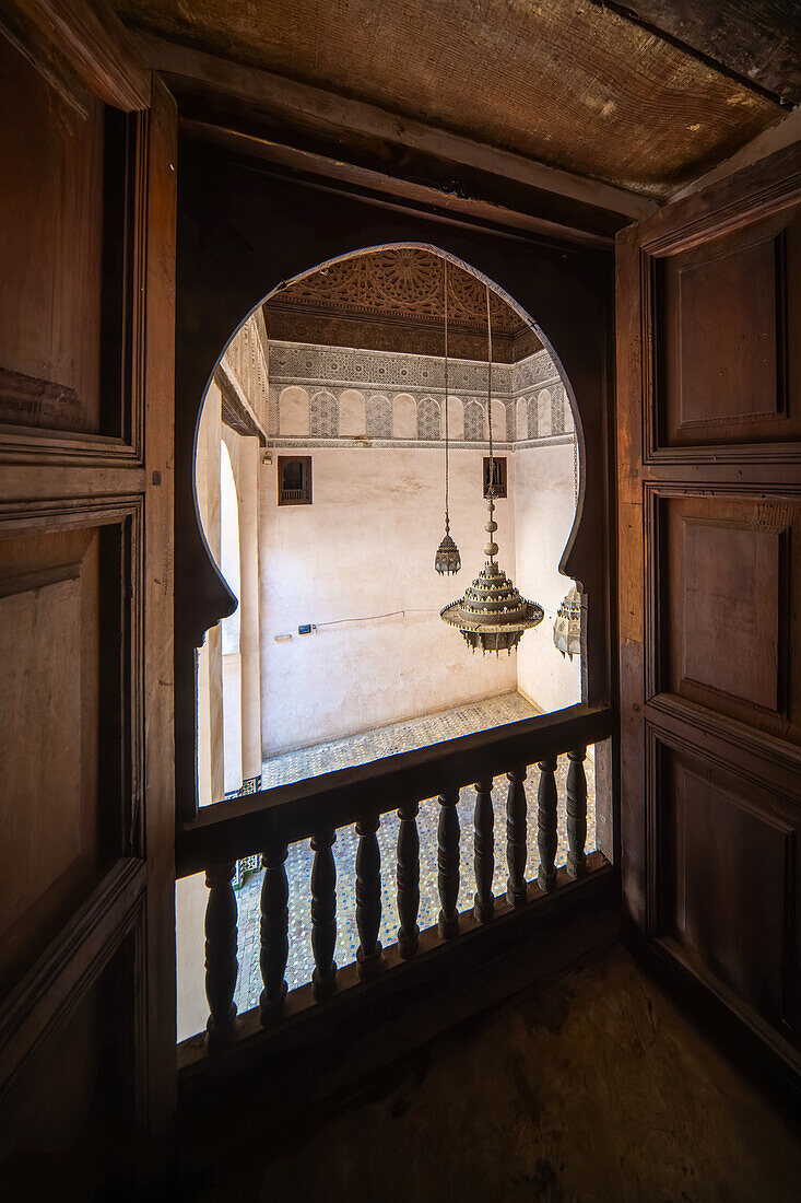 Ein ruhiger Blick durch das verschnörkelte Fenster der Cherratine Madrasa fängt die Essenz von Fez ein. Fez, Marokko.