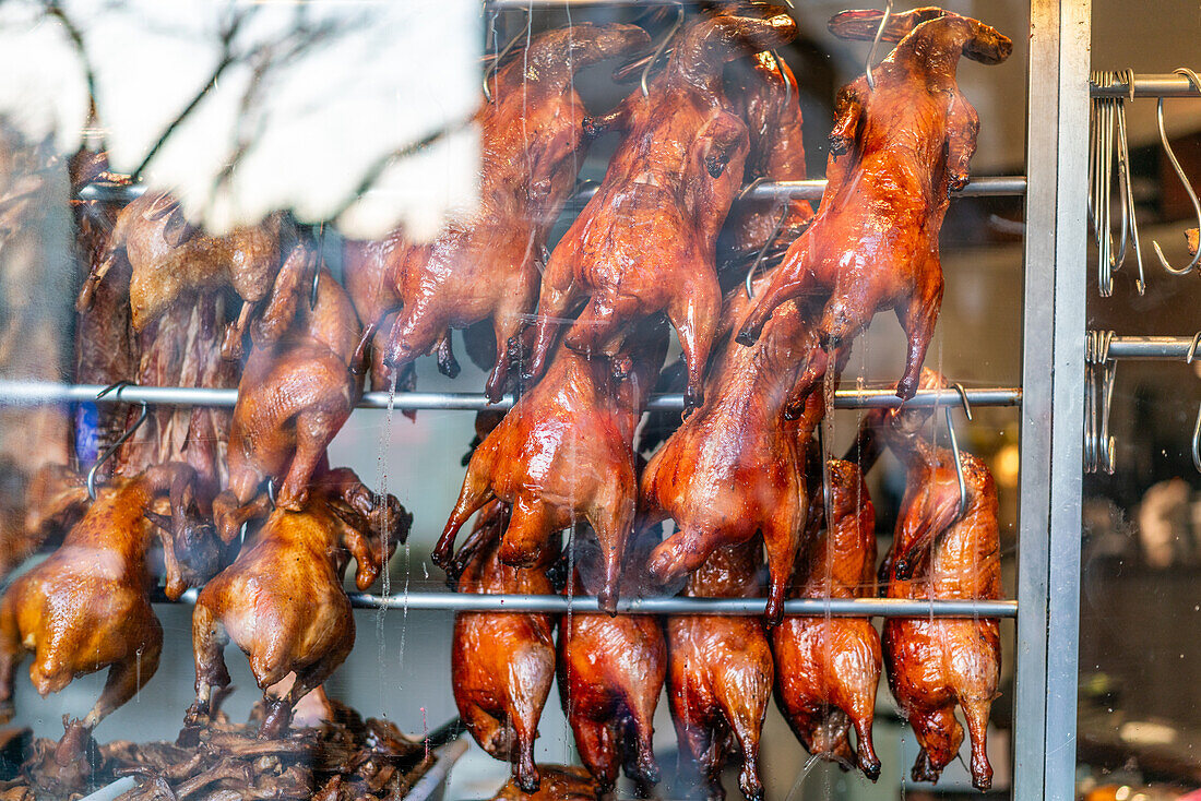 Roast ducks hanging inside a Chinese restaurant window in Bellevue, Paris.