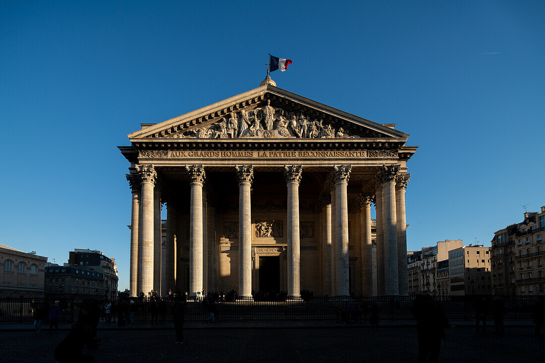 Die untergehende Sonne wirft Schatten auf die große neoklassizistische Fassade des Panthéons in Paris.