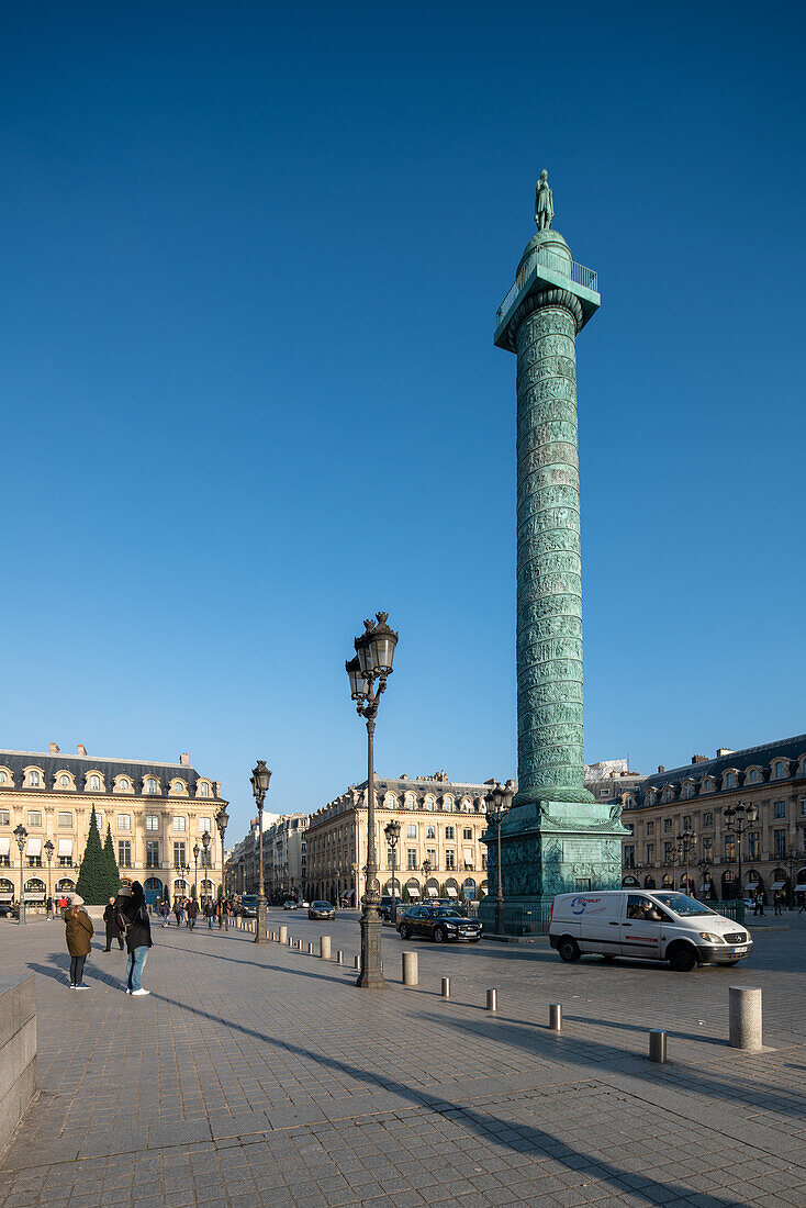 Fußgänger in der Nähe der Vendome-Säule bei strahlend blauem Himmel.