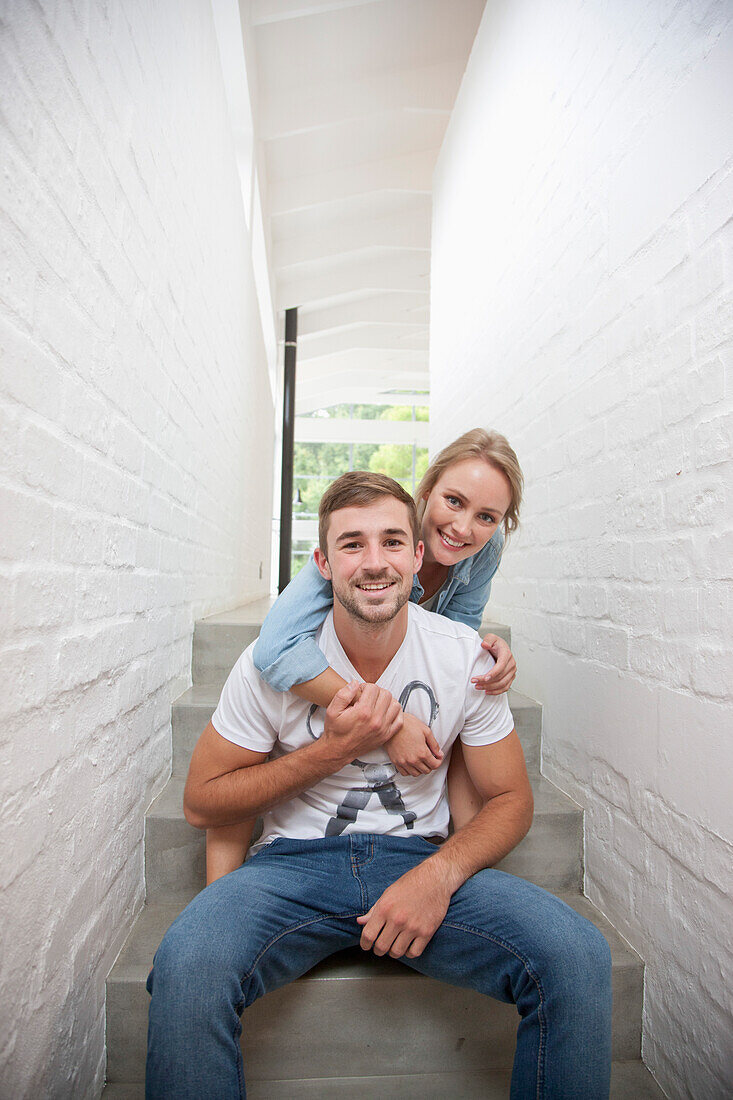 Smiling Young Couple Sitting on Stairs