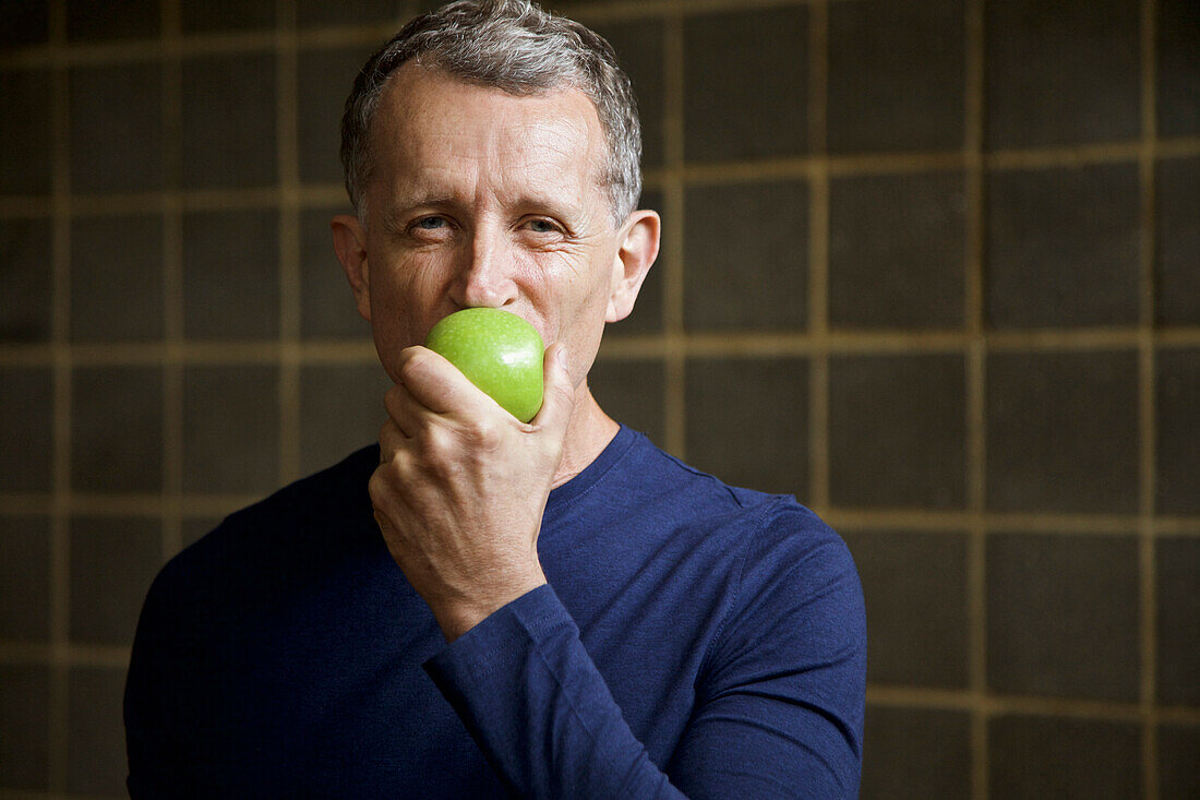 Mature Man Biting an Apple