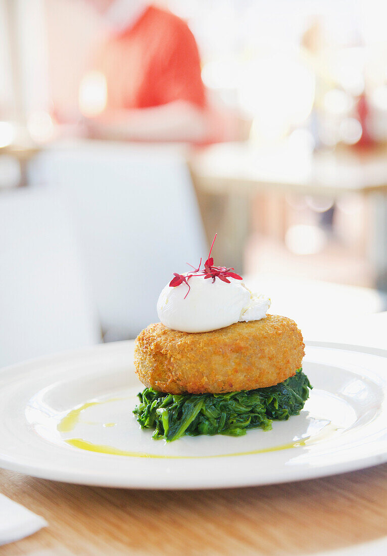 Fischfrikadelle mit Seehecht auf Spinat und pochiertem Ei