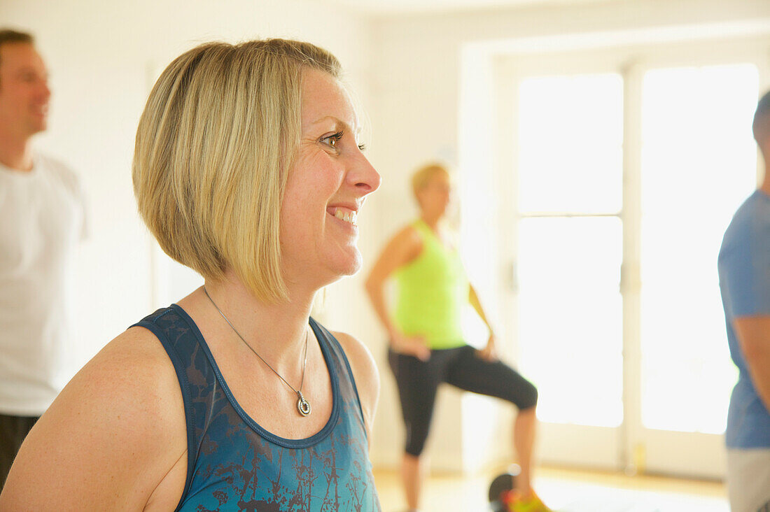 Lächelnde Frau beim Fitnesskurs