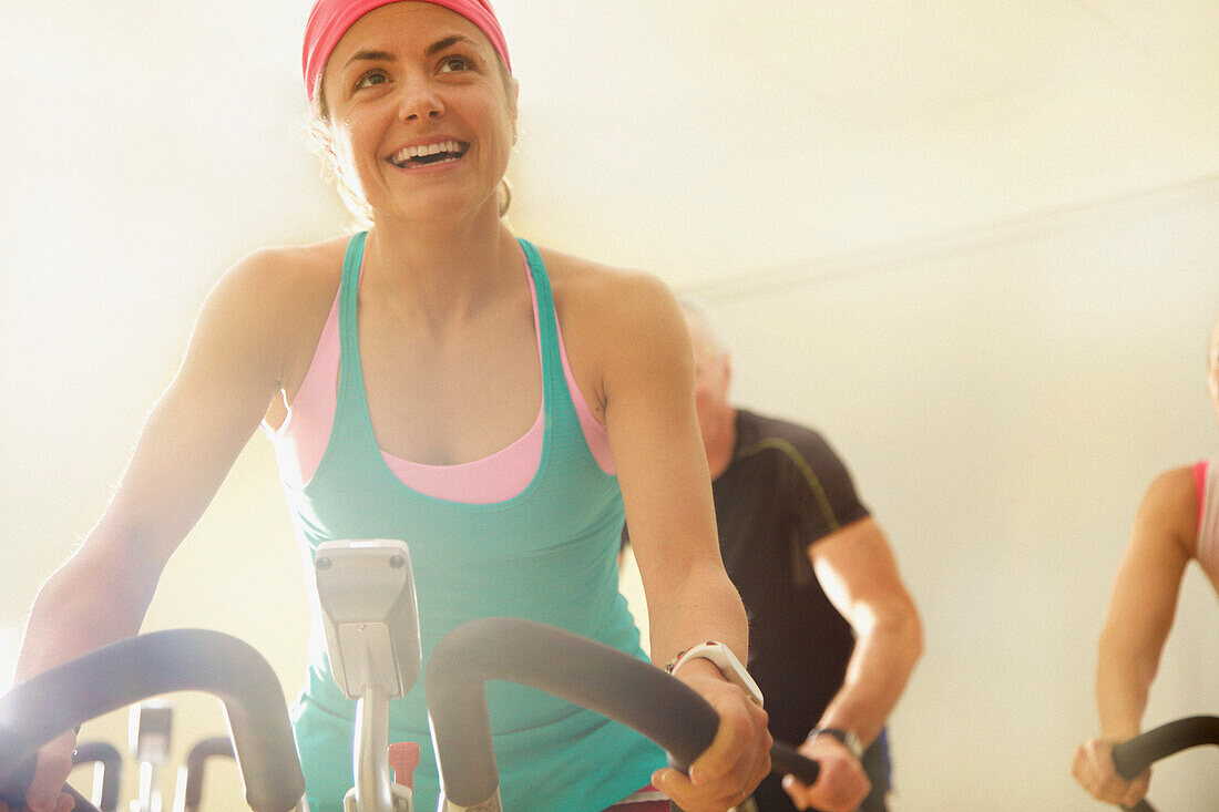 Woman Using Exercise Bicycle at Fitness Class