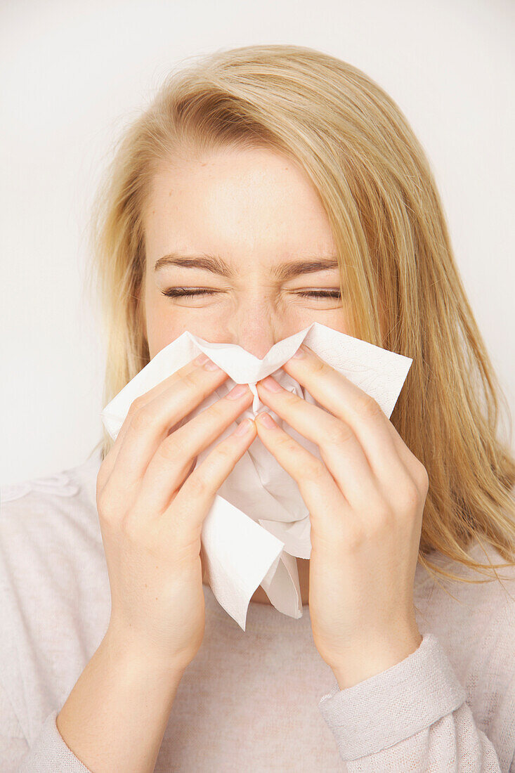 Young Woman Blowing her Nose Sneezing