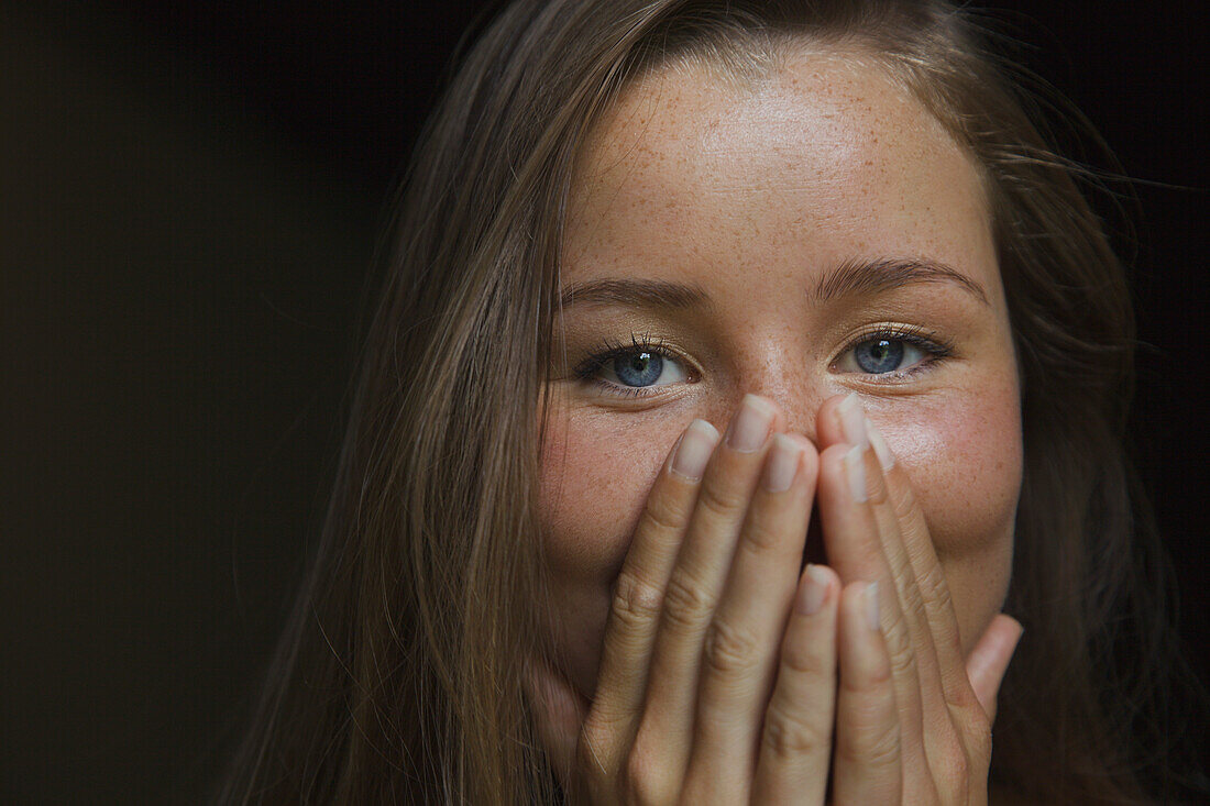 Young Woman with Hands over Mouth