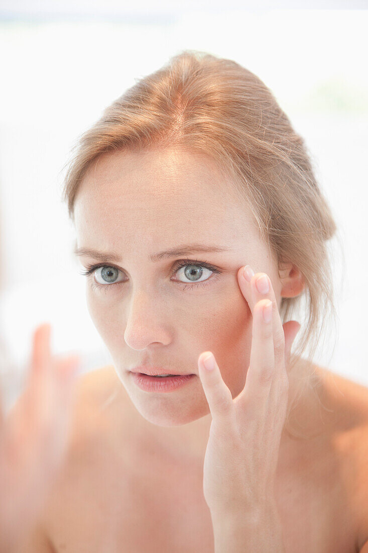 Concerned Woman Looking in Mirror Checking her Face