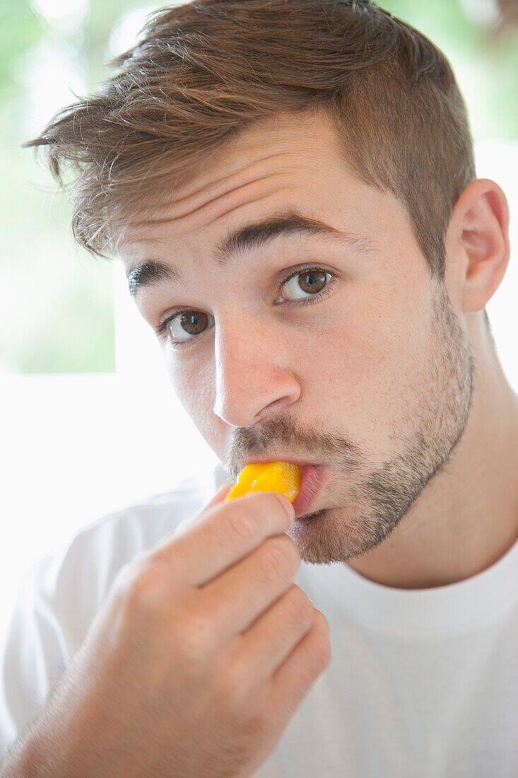 Man Biting Slice of Mango