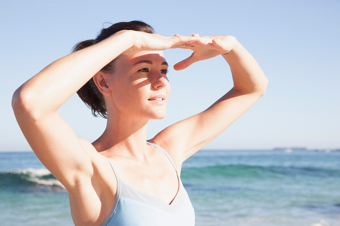 Woman on Beach Shielding her Eyes