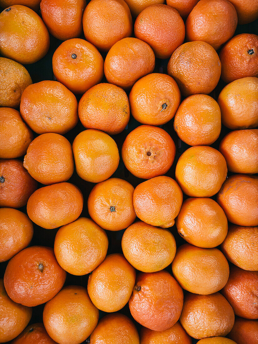 Vollbildansicht von oben auf leuchtend orangefarbene Clementinen