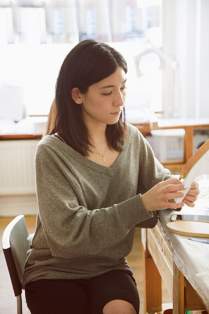 Frau bei der Arbeit im Stickereistudio