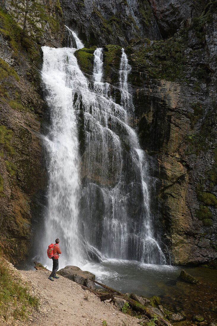 Austria,Styria,ENNSTAL Alps, a man stands in front of a high water fall in the Wasserlochklamm  gorge