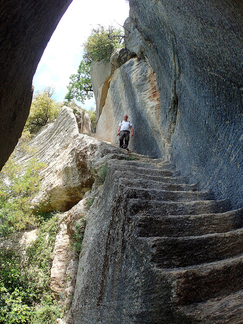 France ,Vaucluse,Provence,the Buoux fort,a man is walking down the monumental troglodytic staircase carving from the cliff called the hidden staircase