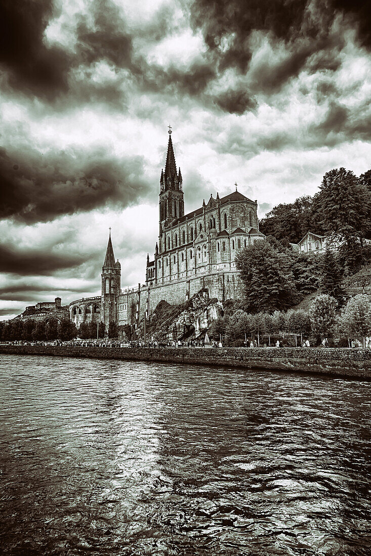 LOURDES - 15. JUNI 2019: Blick auf die Grotte, die Kathedrale, die Burg und die Pilger des Heiligtums von Lourdes,Frankreich