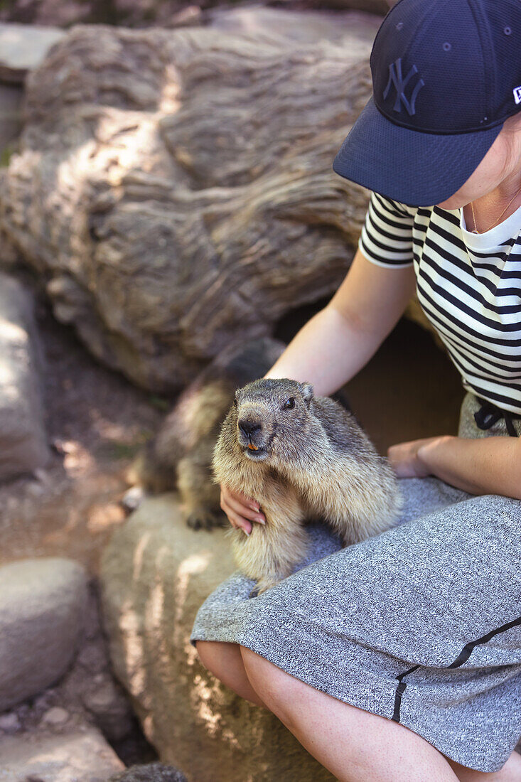 Porträt einer jungen Frau, die Murmeltiere füttert