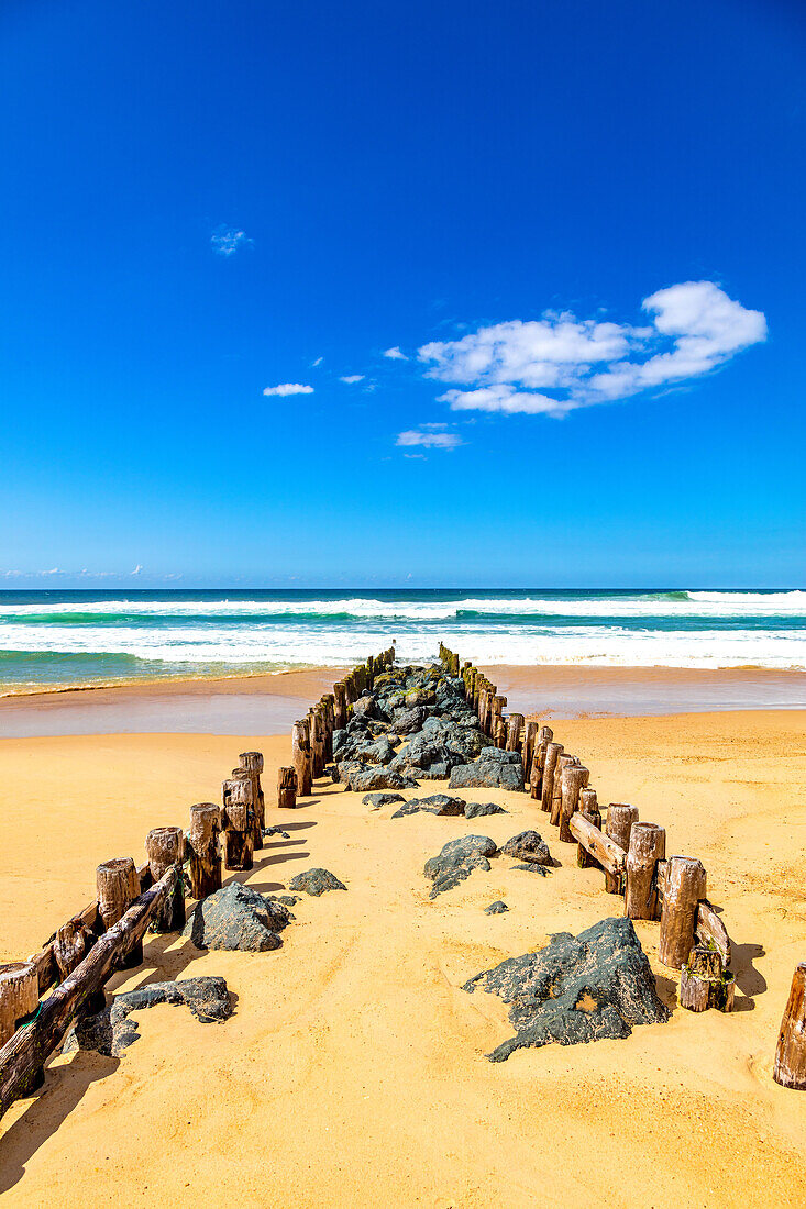 Blick auf Holzpfeiler und Steine am Strand von Seignosse,Landes,Frankreich