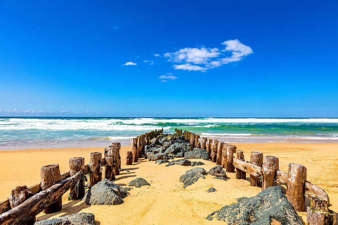 Blick auf Holzpfeiler und Steine am Strand von Seignosse,Landes,Frankreich