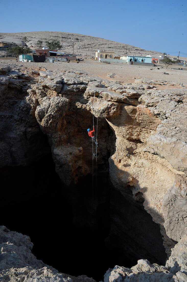 Sultanat Oman,AS Sharqiyah Region,Salma Plateau,Höhle von Majlis Al Jinns,ein Mann seilt sich in den Abgrund von Majlis Al Jinns ab