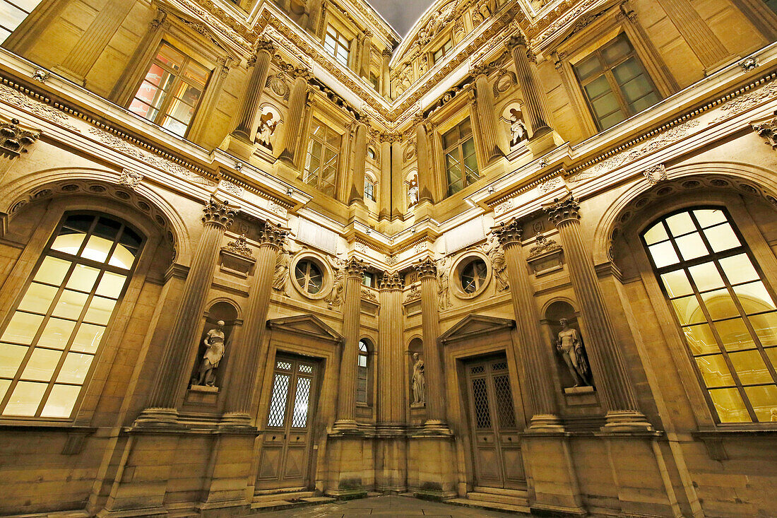 Paris. 1st district. Louvre Museum by night. Square courtyard. Facade of the Clock Pavilion. Architectural detail.