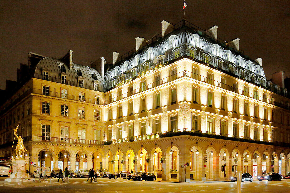 Paris. 1st district. Pyramids Square at night. Equestrian statue representing Joan of Arc on the left. Hotel Regina on the right.