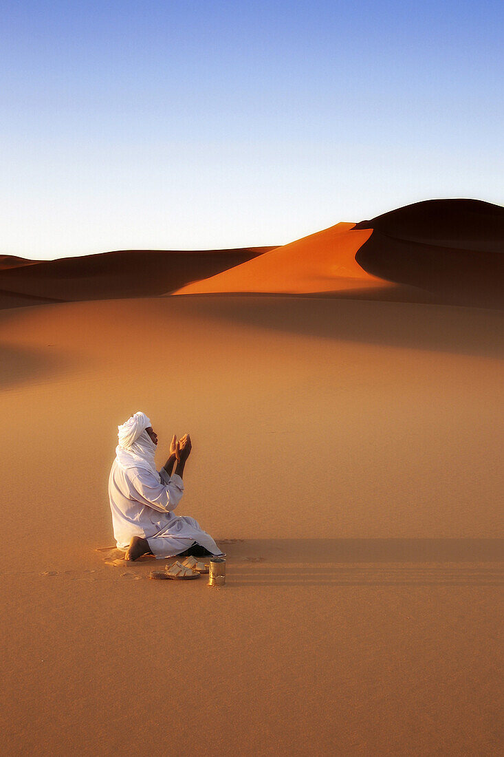 Libya,erg Ubari,Tuareg praying in the desert,dunes.