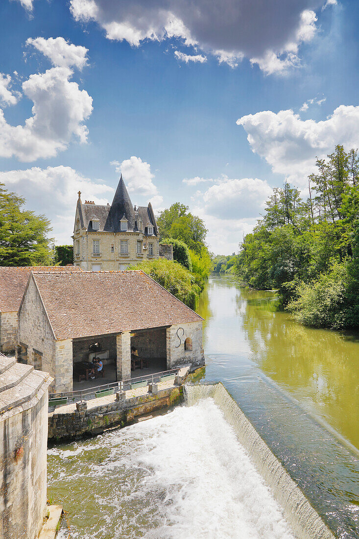 France. Seine et Marne. Medieval village of Moret sur Loing. Tourists picnicking in the foreground.