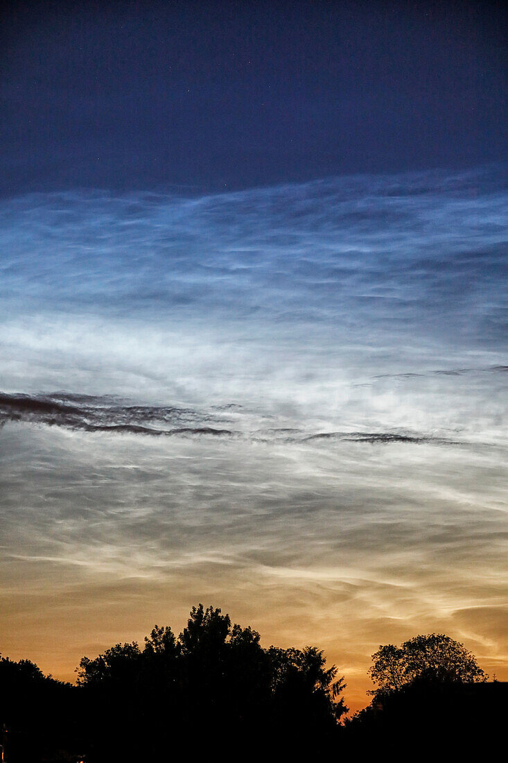 France. Seine et Marne. Coulommiers region. Noctilucent clouds visible in the sky at the beginning of the night on June 18,2021. These clouds are composed of ice and are located at the limit of space (about 80 km altitude).