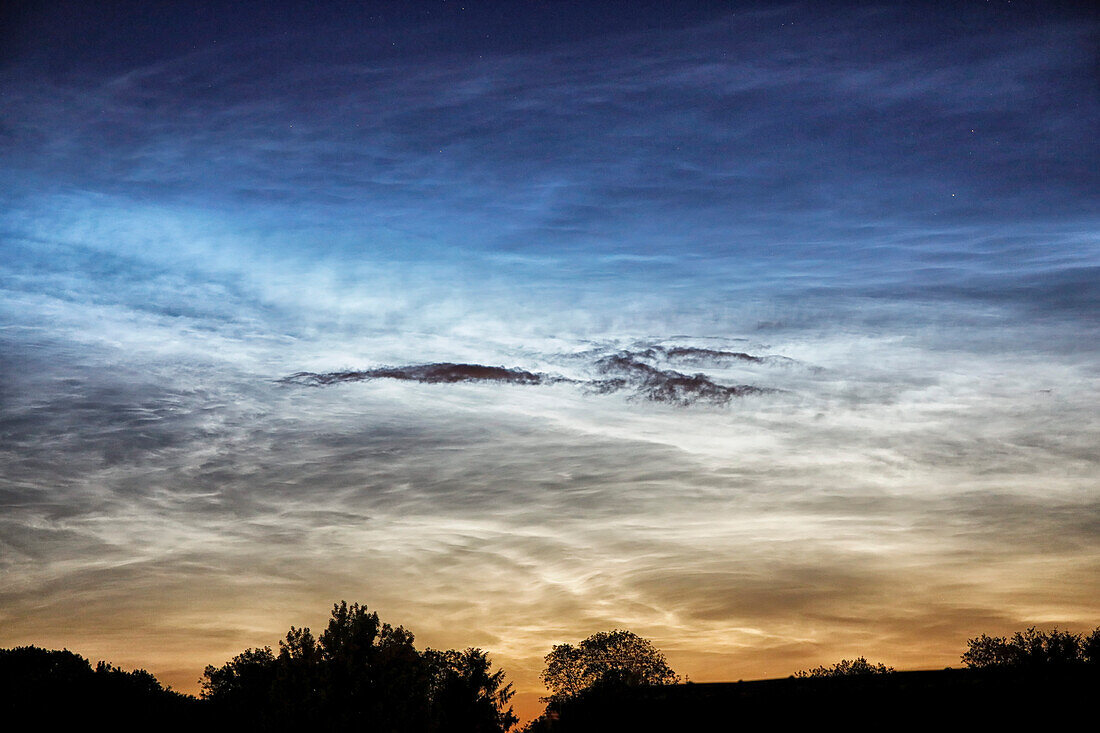 France. Seine et Marne. Coulommiers region. Noctilucent clouds visible in the sky at the beginning of the night on June 18,2021. These clouds are composed of ice and are located at the limit of space (about 80 km altitude).