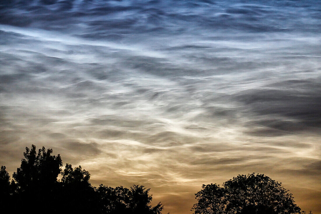 France. Seine et Marne. Coulommiers region. Noctilucent clouds visible in the sky at the beginning of the night on June 18,2021. These clouds are composed of ice and are located at the limit of space (about 80 km altitude).