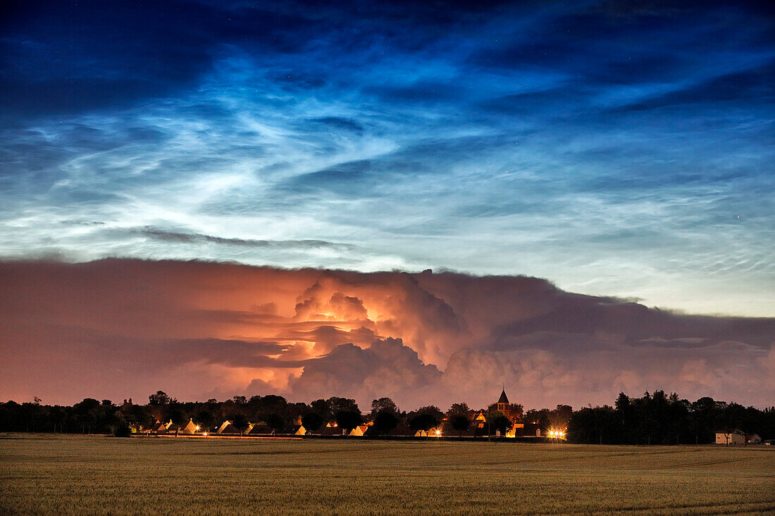 France. Seine et Marne. Coulommiers region. Noctilucent clouds visible in the sky at the beginning of the night on June 21,2021. These clouds are composed of ice and are located at the limit of space (about 80 km altitude). Thunderstorms developing