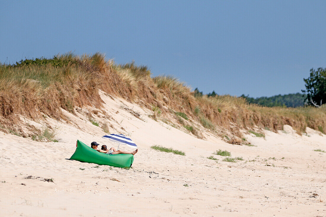 Frankreich. Normandie. Departement Manche. Region Coutances. Pärchen beim Sonnenbaden an einem wilden Strand.