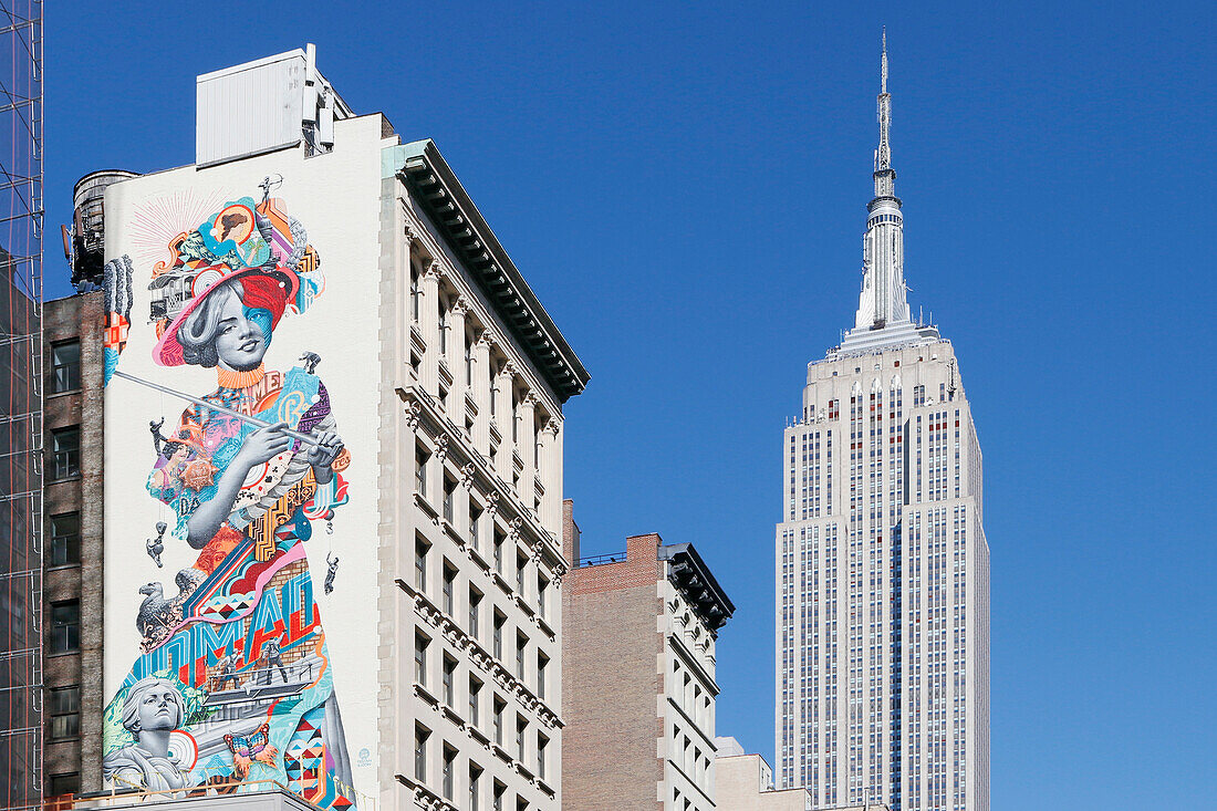 USA. New York City. Manhattan. Empire State Building. Blick von der Straße aus. Im Vordergrund ist Straßenkunst zu sehen.