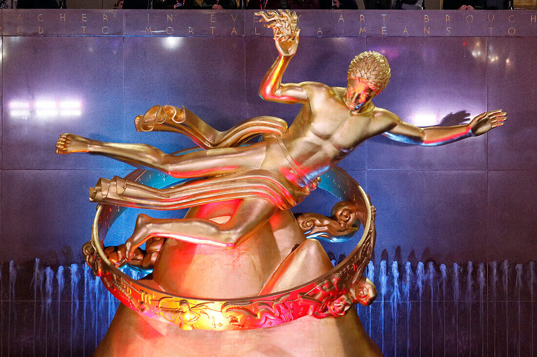 USA. New York City. Manhattan. Rockefeller Center im Winter. Statue Prometheus, von Paul Howard Manship (1885 - 1966). Eisbahn. Touristen beim Schlittschuhlaufen.