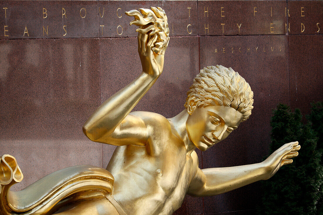 USA. New York City. Manhattan. Rockefeller Center im Winter. Statue Prometheus, von Paul Howard Manship (1885 - 1966). Eisbahn. Touristen beim Schlittschuhlaufen.