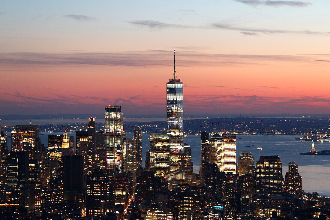 USA. New York City. Manhattan. Empire State Building. Blick von der Spitze des Gebäudes in der Abenddämmerung und bei Nacht. Blick auf das One World Trade Center und die Unterstadt. Der Hudson River ist rechts zu sehen.