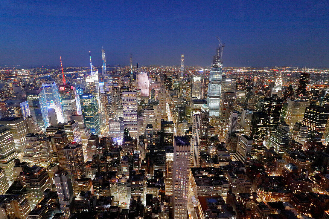 USA. New York City. Manhattan. Empire State Building. Blick von der Spitze des Gebäudes in der Abenddämmerung und bei Nacht. Blick auf das One World Trade Center und die Unterstadt. Der Hudson River ist rechts zu sehen.