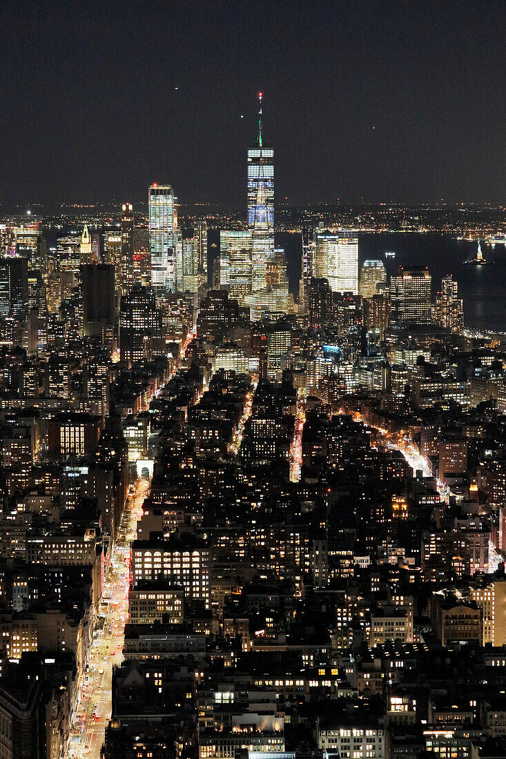 USA. New York City. Manhattan. Empire State Building. Blick von der Spitze des Gebäudes in der Abenddämmerung und bei Nacht. Blick auf das One World Trade Center und die Unterstadt. Der Hudson River ist rechts zu sehen.