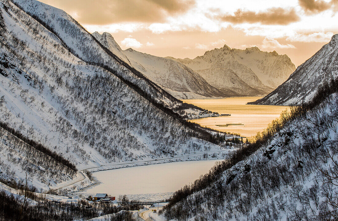 Norway,city of Tromso,Island of Senja,fjord covered with snow at sunset