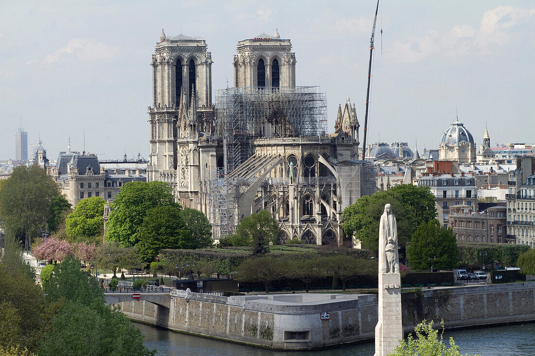 France,Paris,75,1st arrondissement,Ile de la Cite,Cathedral Notre-Dame,after the fire,in the foreground the statue of Saint-Genevieve,Holy Patroness of Paris,at the Pont de la Tournelle,April,17th 2019