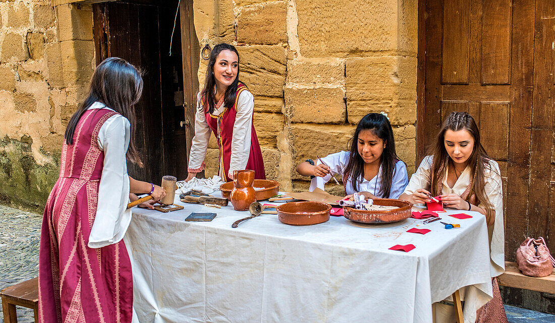 Spain,Rioja,Medieval Days of Briones (festival declared of national tourist interest),young girls in costume on a handicraft stand