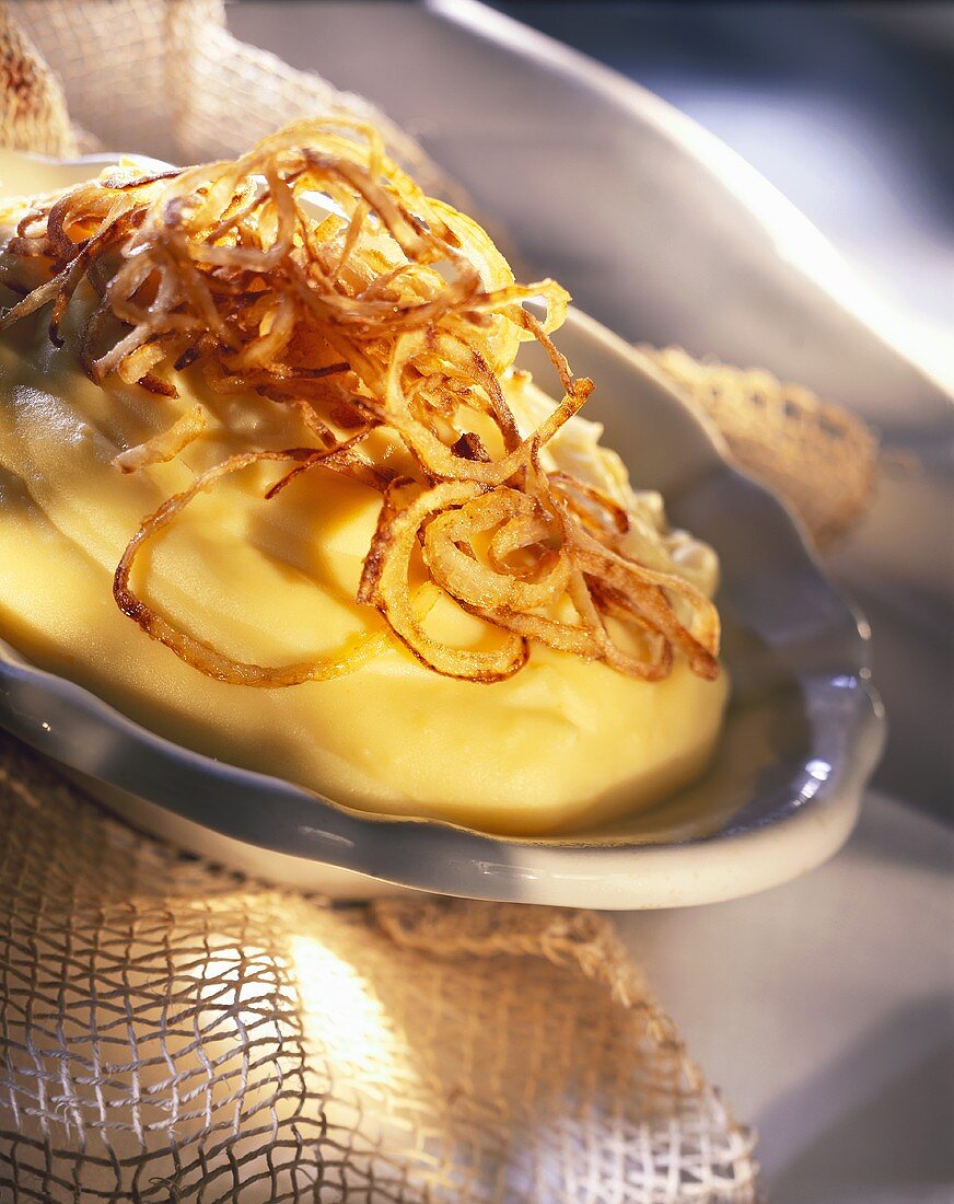 Mashed potato with roasted onions on plate
