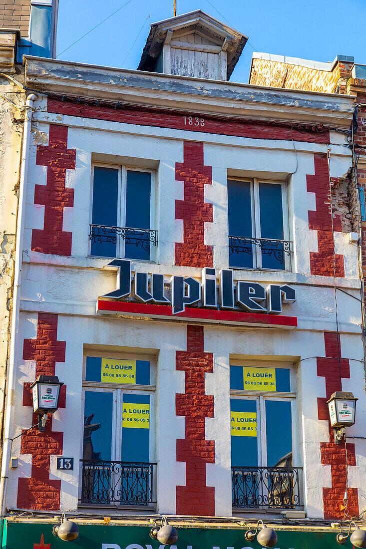 Jupiler-Bierschild an einer alten Fassade in den Hauts de France