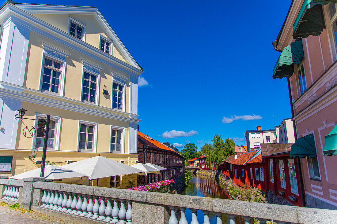 Europe,Scandinavia,Sweden.. Vaestmanland. Vaesteras. Red wooden houses on the banks of the Svartan river