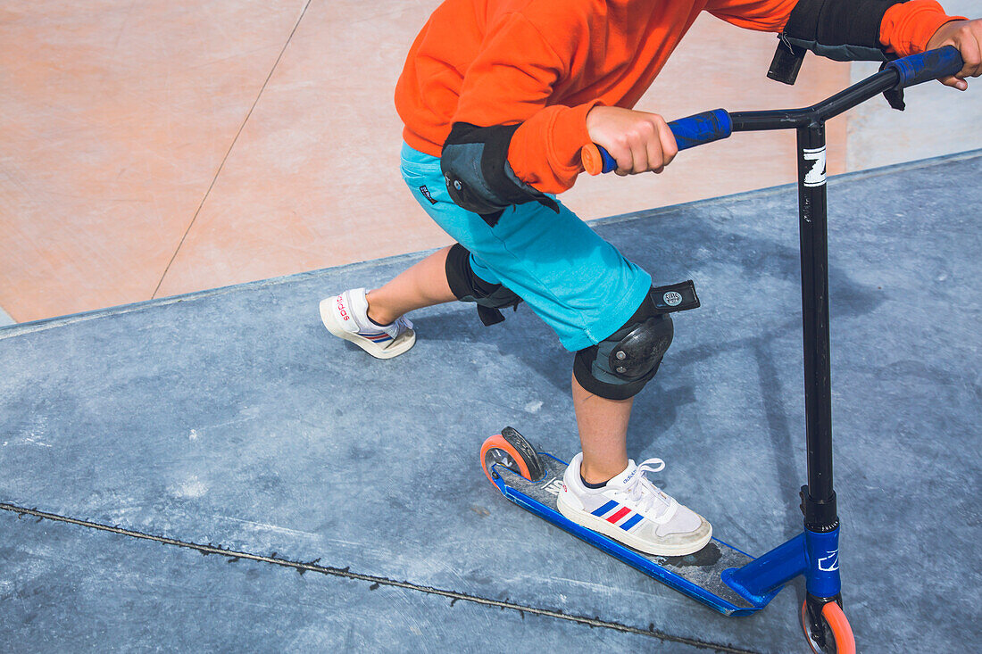 Teen riding a scooter in a skatepark